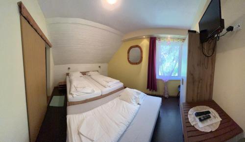 a small room with two beds and a tv at Klammer Gasthof in Kremsbrücke