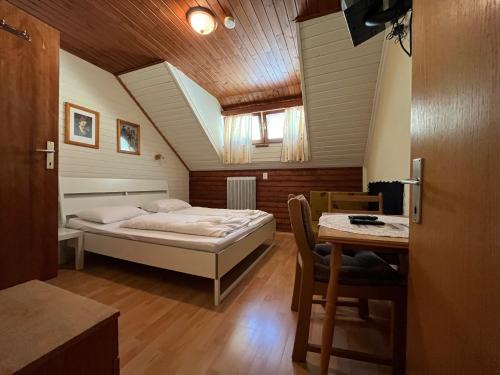 um quarto com uma cama e uma mesa num quarto em Klammer Gasthof em Kremsbrücke