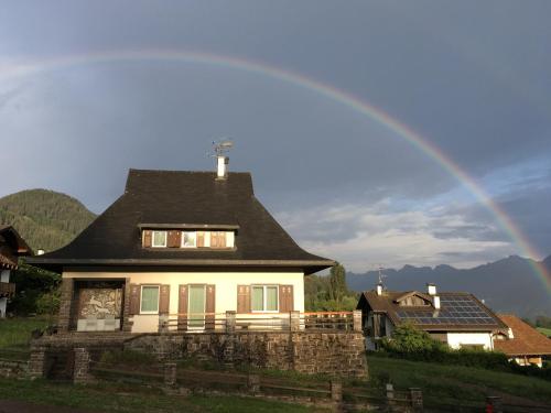 un arco iris sobre una casa con en Villa Molteni, Ville di Fiemme, Varena, en Varena