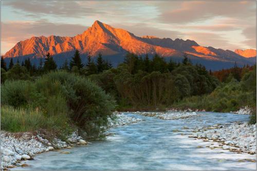 a river with a mountain in the background at Turistická ubytovňa in Liptovský Mikuláš