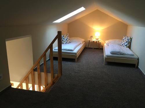 a attic room with two beds and a staircase at Ferienhaus Anker in Zudar
