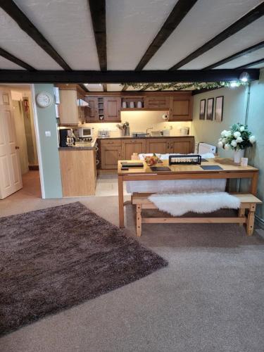 a large kitchen with a table and benches in it at The Granary Corris on the edge of the Dyfi Forest in Corris