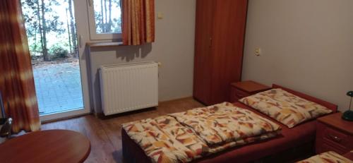 a room with two beds and a table and a window at Zajazd U Doktora in Lubrza