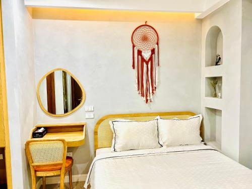 a bedroom with a bed and a desk and a mirror at Rova Hotel Phú Quốc in Phú Quốc