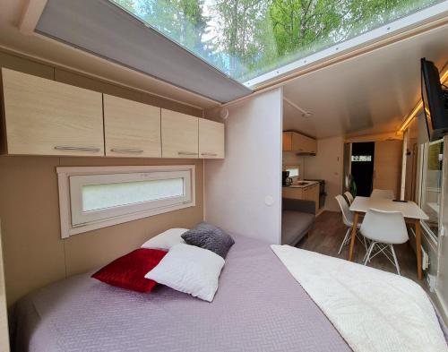 a small bedroom with a bed with a window at Mansikkaharju Holiday Camp in Leppävirta