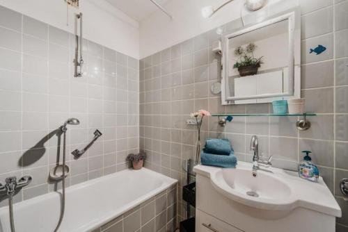 uma casa de banho com um lavatório, uma banheira e um espelho. em kleiner Wumbi Braunlage em Braunlage