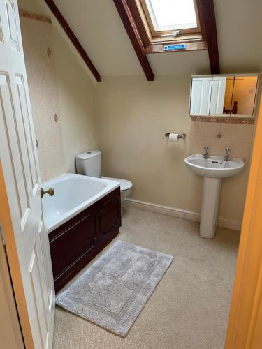 a bathroom with a bath tub and a sink at La Follette in Beuzeville