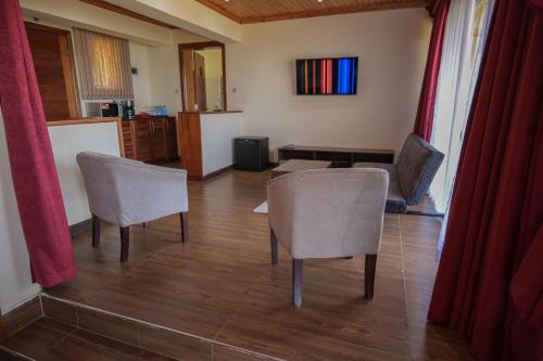 a living room with two chairs and a table at Lake Elementaita Mountain Lodge in Nakuru