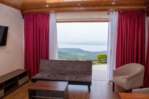 a living room with a couch and a large window at Lake Elementaita Mountain Lodge in Nakuru