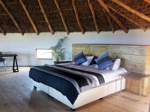 a bedroom with a large bed with a wooden headboard at Swell Eco Lodge in Mdumbi