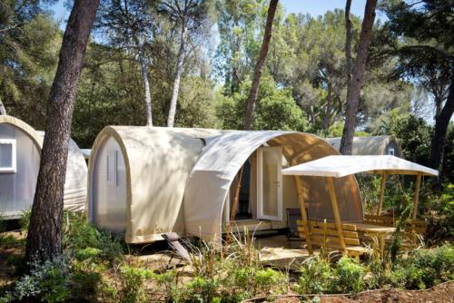 a small home with a tent in the woods at Les Insolites du vélodrome d'Albert in Albert