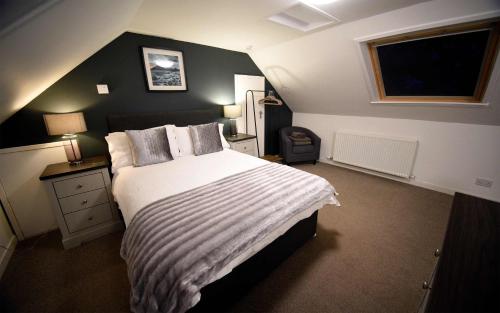 a bedroom with a large bed and a window at Fladda Chuain Holiday Home in Kilmuir