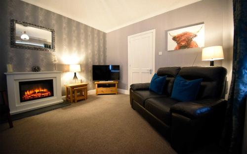 a living room with a couch and a fireplace at Fladda Chuain Holiday Home in Kilmuir