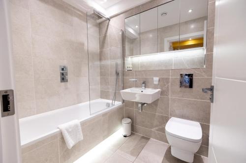 a bathroom with a toilet and a sink and a tub at Two-Bedroom Legoland Windsor Resort by Belvilla in Slough