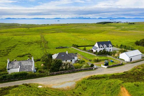 an aerial view of a farm with houses in a field at Fladda Chuain Holiday Home in Kilmuir