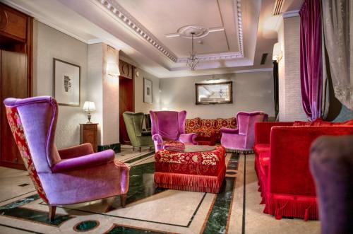 een woonkamer met paarse en rode stoelen bij LH Hotel Andreotti in Rome