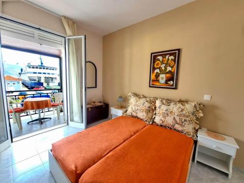 a bedroom with an orange bed and a balcony at "Sun" Bayview apartment in Lixouri