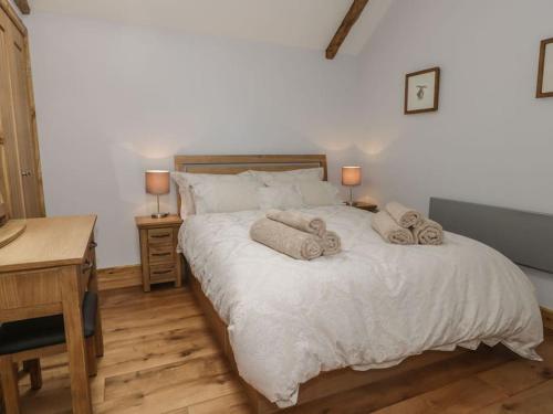 1 dormitorio con 1 cama grande y toallas. en Primrose Holiday Cottage, Dog Friendly, Hot Tub, Winestead, East Yorkshire Coast, en Hull