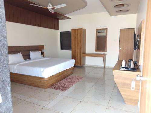 a bedroom with a bed and a television in it at Flamingo Club and Resort Una 3 Km Away from Diu Check Post in Diu