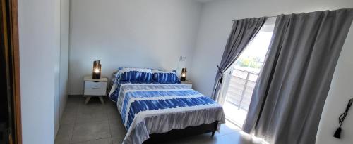 1 dormitorio con cama y ventana grande en Complejo Azahar en Godoy Cruz