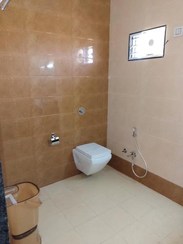 a bathroom with a toilet and a window at Flamingo Club and Resort Una 3 Km Away from Diu Check Post in Diu
