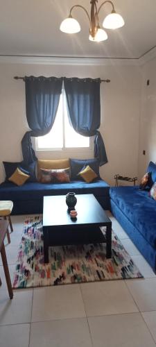 uma sala de estar com um sofá azul e uma mesa de centro em Dyour marjan em Marrakech
