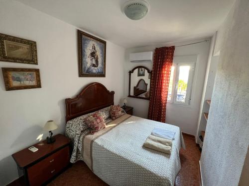 Habitación pequeña con cama y ventana en Bonitas habitacións en piso compartido casa antonio, en Sevilla
