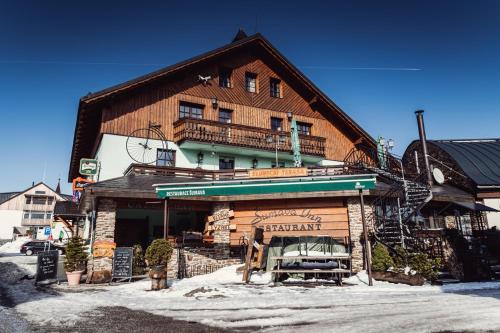 un gran edificio de madera con un cartel delante en Šumava Inn, en Kvilda