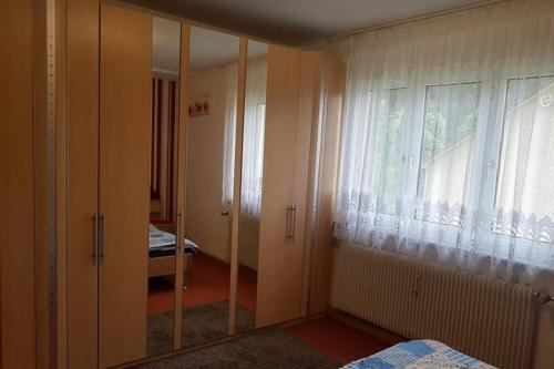a bedroom with a mirror and a bed and a window at 2 Rooms Apartment in Triberg in Triberg