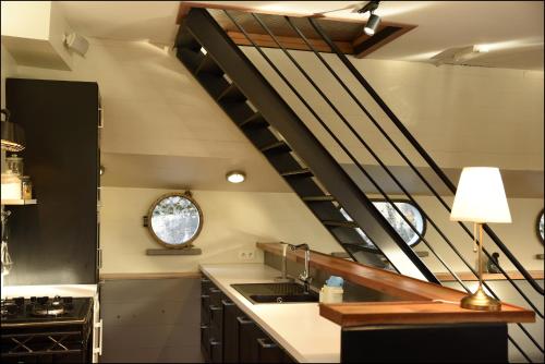 a kitchen with a spiral staircase in a house at Péniche Rayclau in Ronquières
