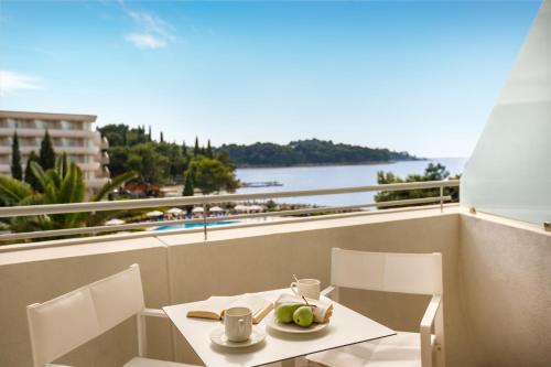 a table and chairs on a balcony with a view of the water at Remisens Hotel Albatros-All inclusive in Cavtat