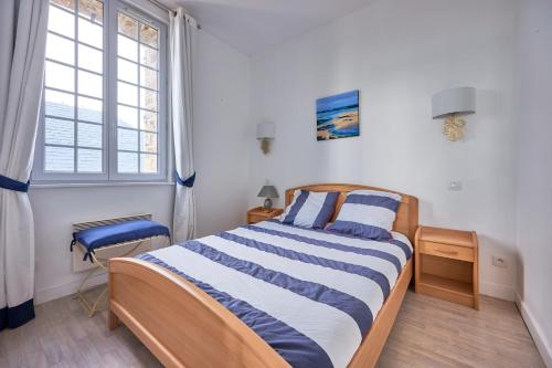 een slaapkamer met een bed met blauwe en witte strepen bij Château de Chimay - Appt en front de mer in Barneville-Carteret