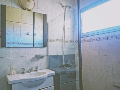 y baño con lavabo y ducha. en Amplio departamento en el corazón de Mendoza en Mendoza