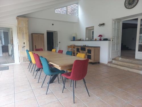une salle à manger avec une table en bois et des chaises colorées dans l'établissement COUL'Ô'BERGE, à Coulanges-lès-Nevers