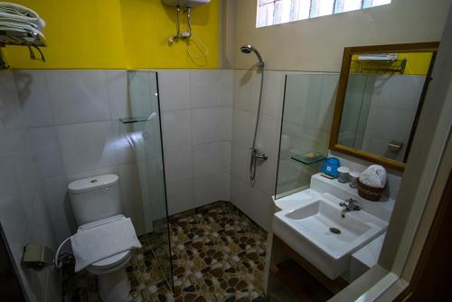 een badkamer met een toilet, een wastafel en een douche bij Bella Vista Premium Homestay in Banyuwangi