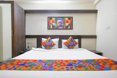a bedroom with a bed with a colorful comforter at FabExpress Golden Villa in Indore