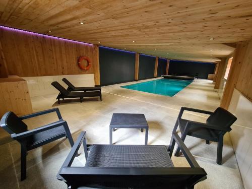 a swimming pool in a room with chairs and tables at Ash Cottage in Hope