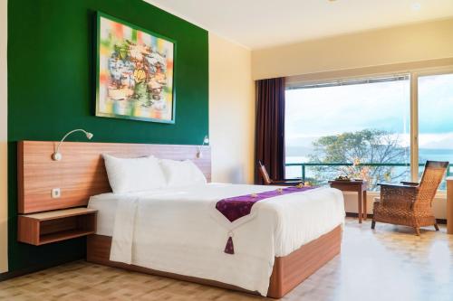 バニュワンギにあるBella Vista Premium Homestayの緑の壁のベッドルーム1室(大型ベッド1台付)
