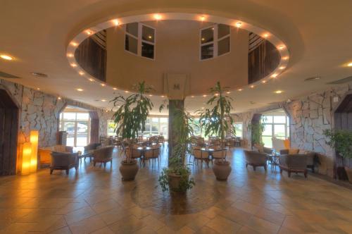 a restaurant with tables and chairs and a large ceiling at Marcin Hotel in Carilo