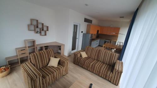 a living room with two chairs and a kitchen at Apartmány Semily in Semily