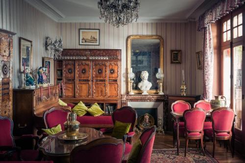 a room with a table and chairs and a mirror at Logis Hôtel Restaurant le Printania in Dinard