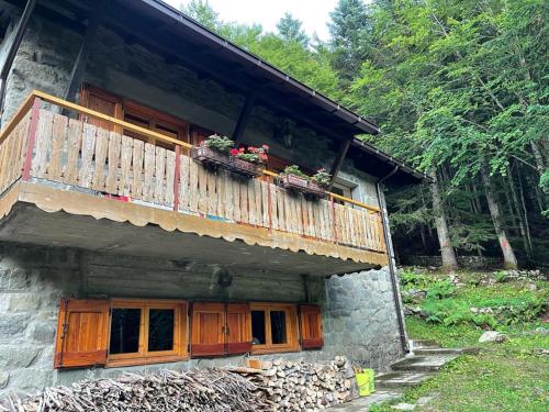 un edificio con un balcón con flores. en Baita Le Pozze, en Abetone