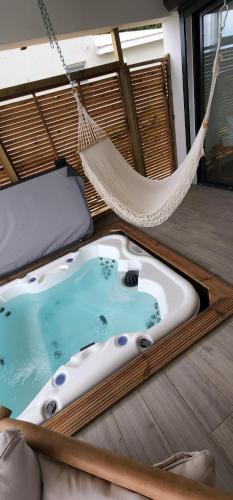 a bath tub in a hammock in a room at La Suite Zen Martinique Luxe SPA/Vue Mer in Le François