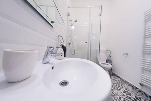La salle de bains blanche est pourvue d'un lavabo et de toilettes. dans l'établissement Central Luxury 1, à Cluj-Napoca