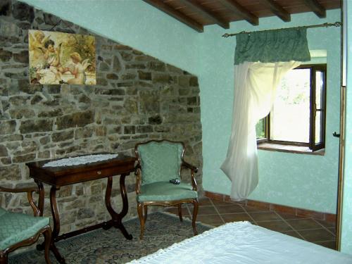 a bedroom with a desk and a chair and a window at Country Farm in Vernio