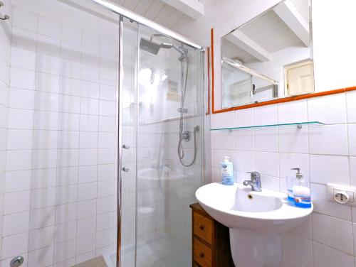 a white bathroom with a sink and a shower at La Casa Delle Fate in Siracusa