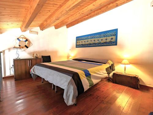 a bedroom with a bed in a room with wooden floors at La Casa Delle Fate in Siracusa