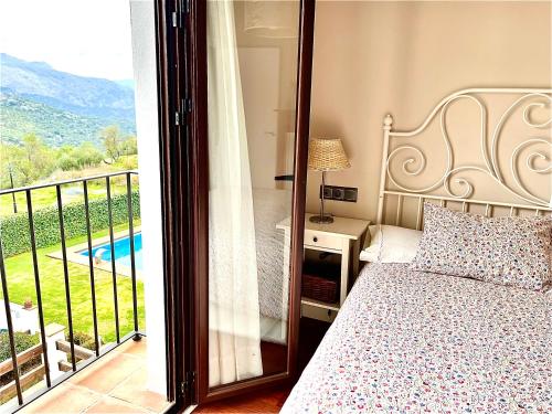 a bedroom with a bed and a balcony with a view at Casa Antonio in Montejaque