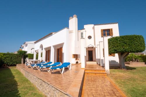 una casa bianca con sedie blu su un patio di Casa Felix a Palma de Mallorca