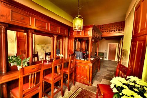 a kitchen with a bar with wooden cabinets and chairs at Hotel Denkmal 13 Wismar in Wismar